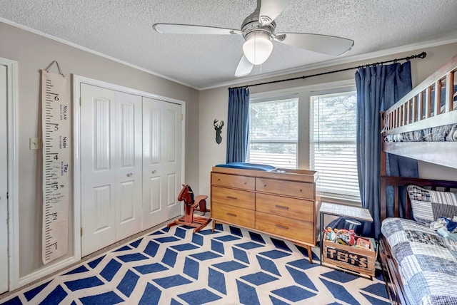 bedroom featuring ornamental molding, a closet, a textured ceiling, and a ceiling fan