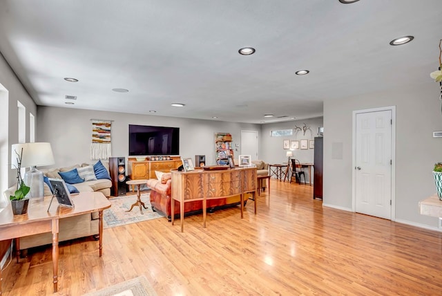 living area with light wood-type flooring, visible vents, baseboards, and recessed lighting