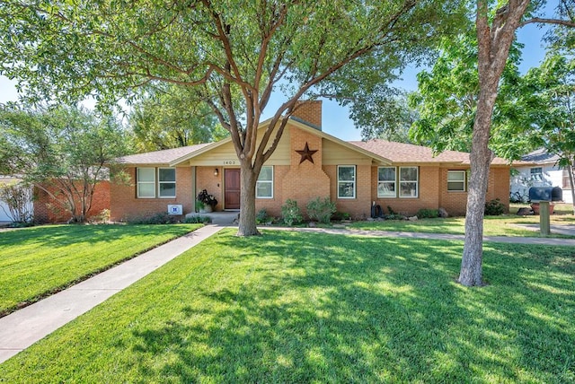 ranch-style home with a front yard, brick siding, and a chimney