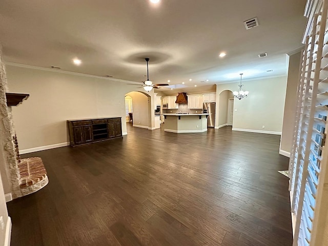 unfurnished living room with crown molding, dark wood-style floors, arched walkways, and visible vents