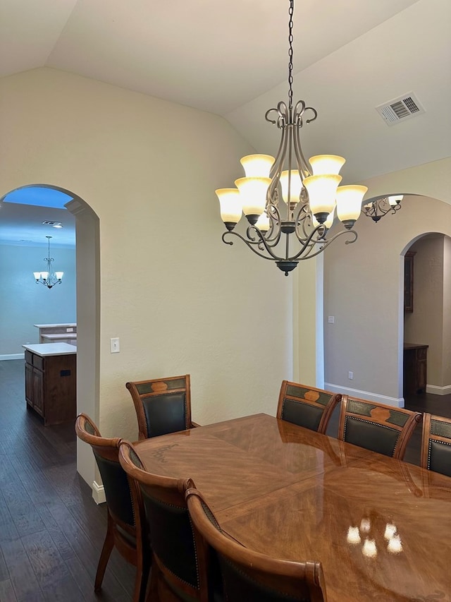 dining area with an inviting chandelier, visible vents, arched walkways, and lofted ceiling