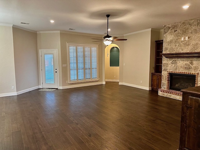 unfurnished living room with visible vents, a ceiling fan, dark wood-style floors, a fireplace, and crown molding