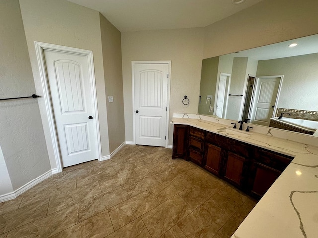 full bathroom with a bathtub, vanity, and baseboards