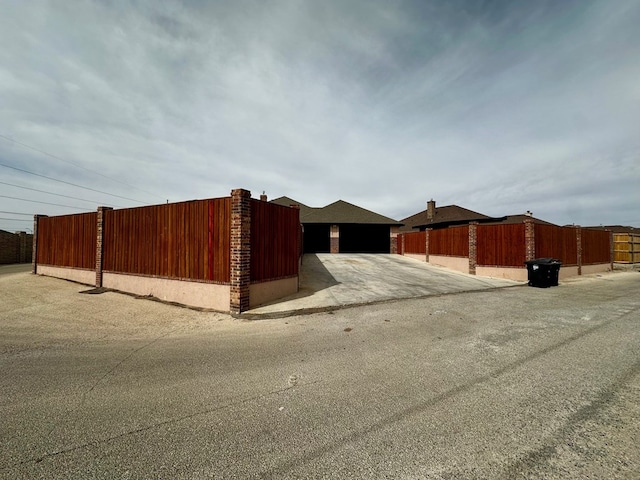 exterior space with a garage, driveway, and fence