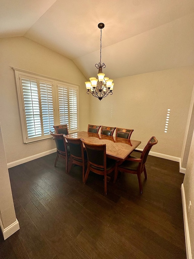 dining space featuring dark wood-type flooring, baseboards, lofted ceiling, and an inviting chandelier