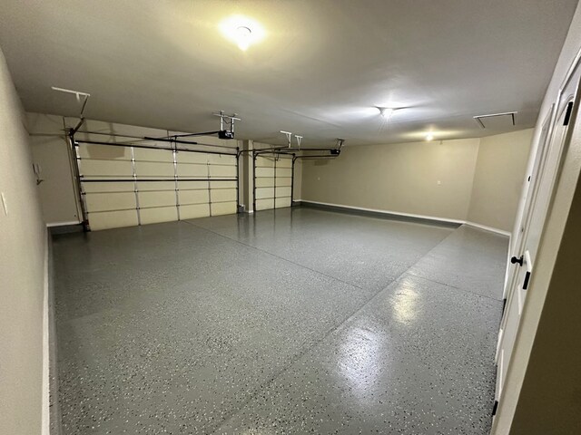 garage featuring a garage door opener and baseboards