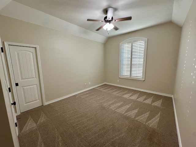 carpeted spare room with baseboards, a ceiling fan, and vaulted ceiling