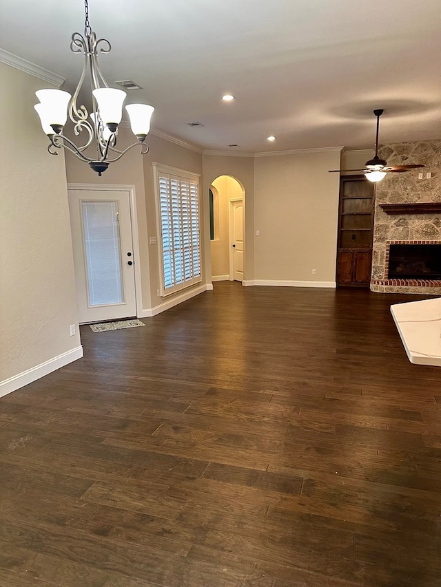 unfurnished living room with arched walkways, dark wood-style floors, and ornamental molding