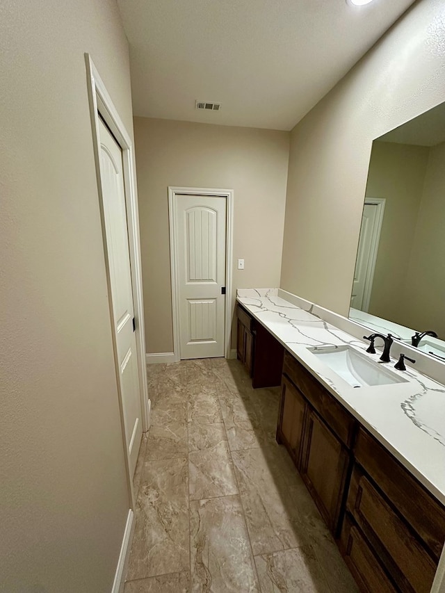 bathroom with visible vents, baseboards, and vanity