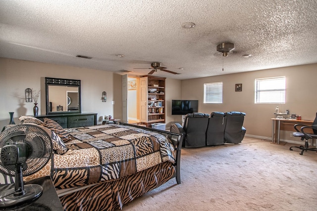 bedroom featuring ceiling fan, a textured ceiling, and light carpet