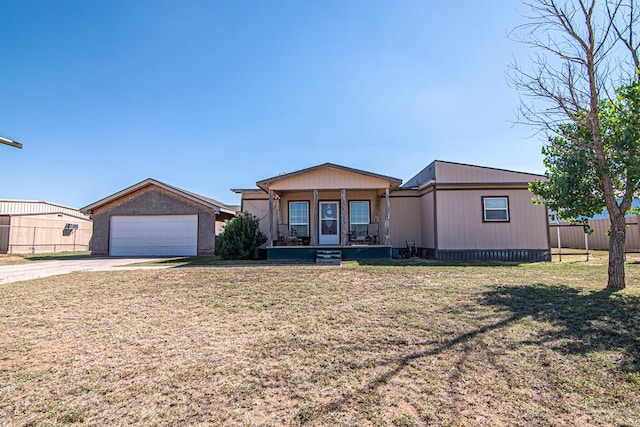 view of front of home with covered porch, a garage, and a front lawn