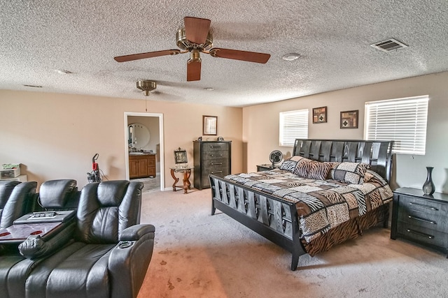 carpeted bedroom with ensuite bath, ceiling fan, and a textured ceiling