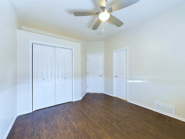 unfurnished bedroom featuring dark wood finished floors, a closet, visible vents, a ceiling fan, and baseboards