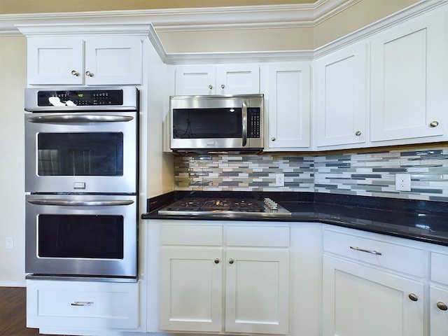 kitchen featuring appliances with stainless steel finishes, dark countertops, and white cabinetry