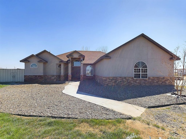 view of front facade featuring stone siding and stucco siding