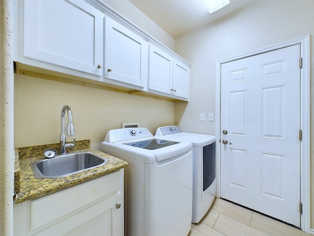 laundry area with cabinet space, washer and clothes dryer, and a sink