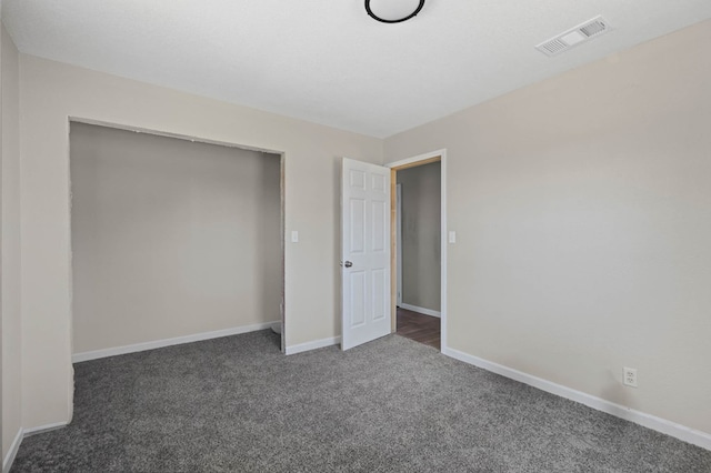 unfurnished bedroom with visible vents, baseboards, a closet, and carpet flooring