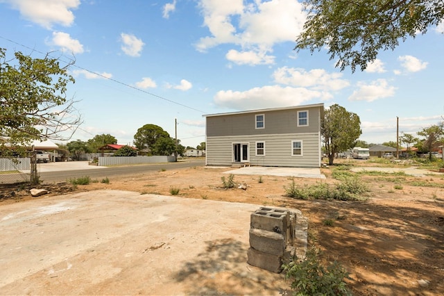 back of property featuring a patio and fence