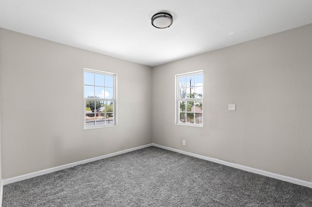 unfurnished room featuring baseboards and plenty of natural light