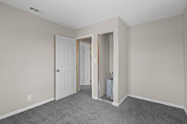 unfurnished bedroom featuring visible vents, carpet floors, and baseboards