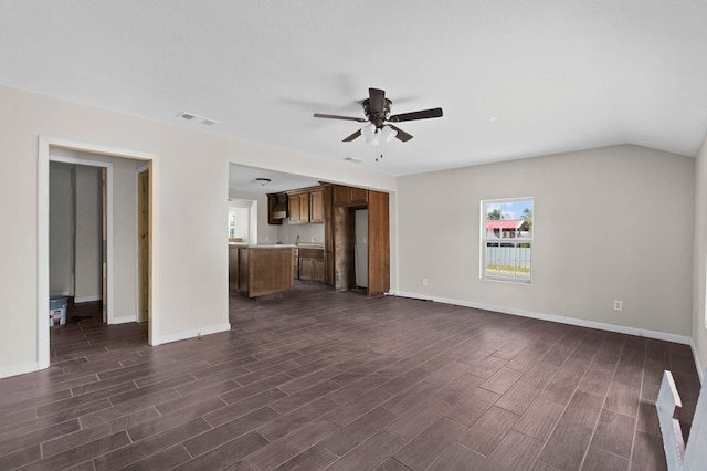 unfurnished living room featuring visible vents, baseboards, dark wood-type flooring, and ceiling fan