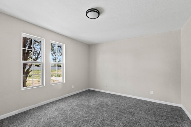 carpeted spare room featuring baseboards