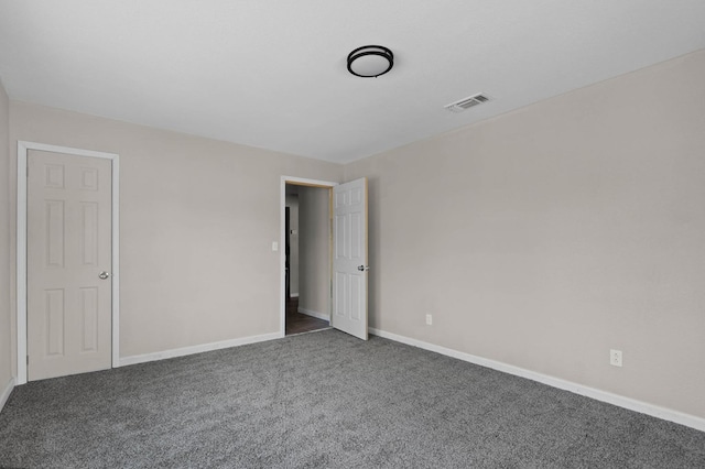 empty room with visible vents, baseboards, and carpet