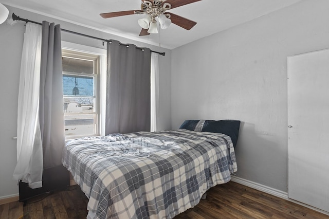 bedroom featuring baseboards, dark wood-style floors, and a ceiling fan