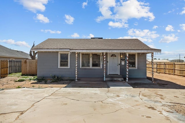 bungalow-style home featuring roof with shingles and fence