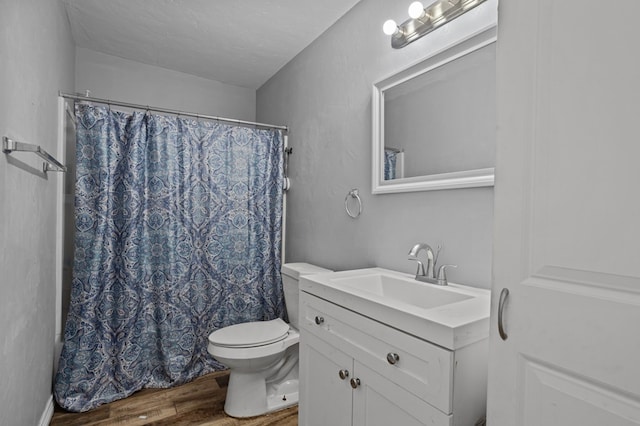 bathroom with a shower with curtain, toilet, wood finished floors, and vanity