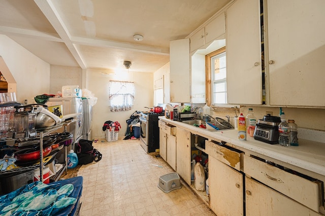 kitchen featuring white cabinets, gas stove, plenty of natural light, and sink