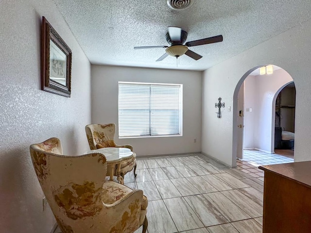 sitting room featuring ceiling fan and a textured ceiling