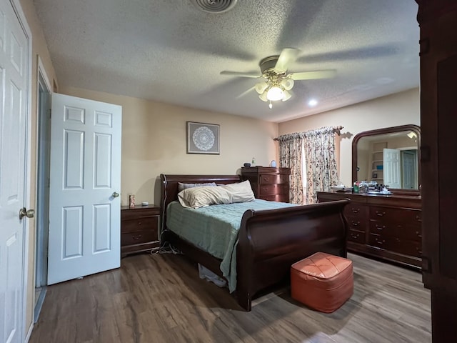 bedroom with wood-type flooring, a textured ceiling, and ceiling fan