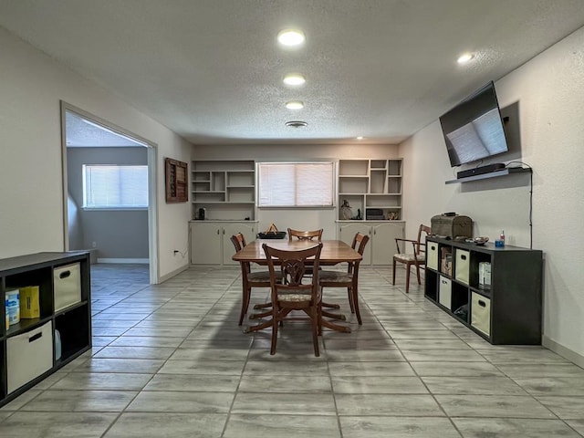 dining area with light tile patterned floors and a textured ceiling