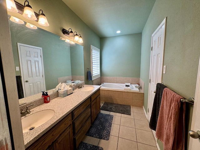 bathroom featuring tile patterned floors, tiled bath, and vanity