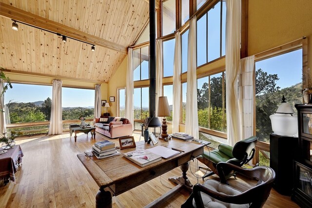 sunroom / solarium featuring lofted ceiling with beams and wooden ceiling