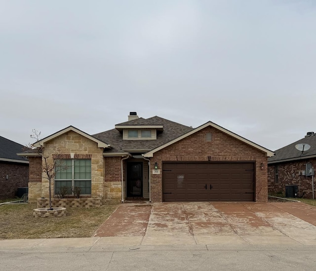 view of front of property featuring cooling unit and a garage