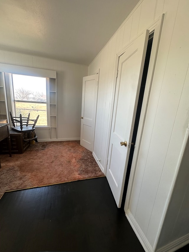 office area featuring dark colored carpet and dark wood-style flooring