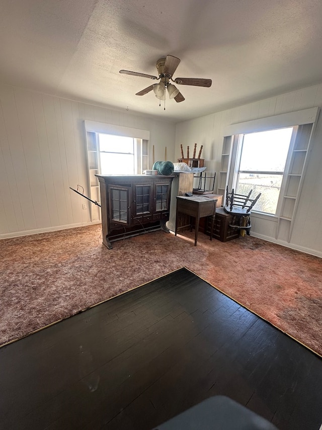 interior space with a textured ceiling, wood finished floors, and a ceiling fan