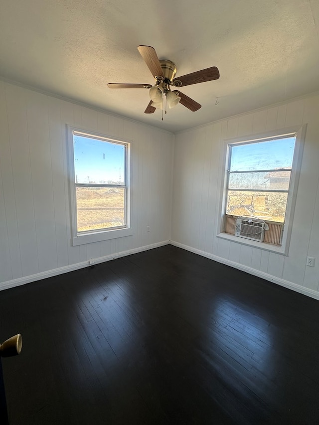 unfurnished room featuring a healthy amount of sunlight, dark wood-style floors, a textured ceiling, and a ceiling fan