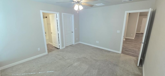 unfurnished bedroom with visible vents, baseboards, ensuite bath, and carpet flooring