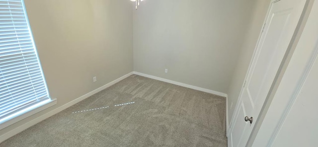 empty room with light colored carpet and baseboards