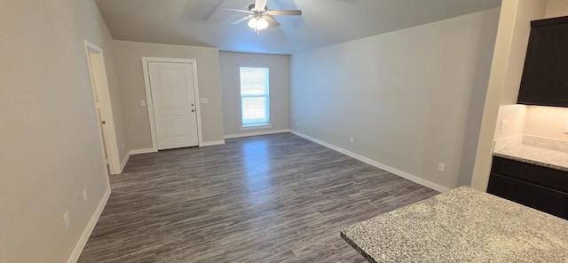 interior space with ceiling fan, baseboards, and dark wood-style floors