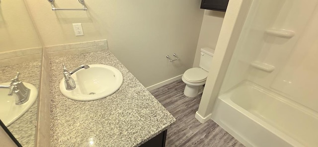 bathroom featuring vanity, toilet, wood finished floors, and baseboards