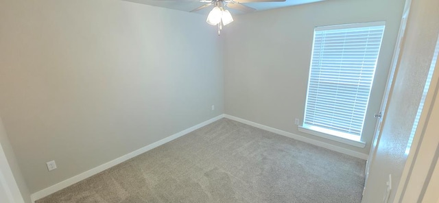 spare room featuring baseboards, a ceiling fan, and carpet flooring