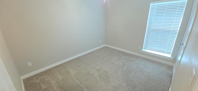 carpeted empty room with baseboards