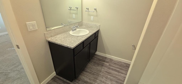 bathroom with vanity, baseboards, and wood finished floors