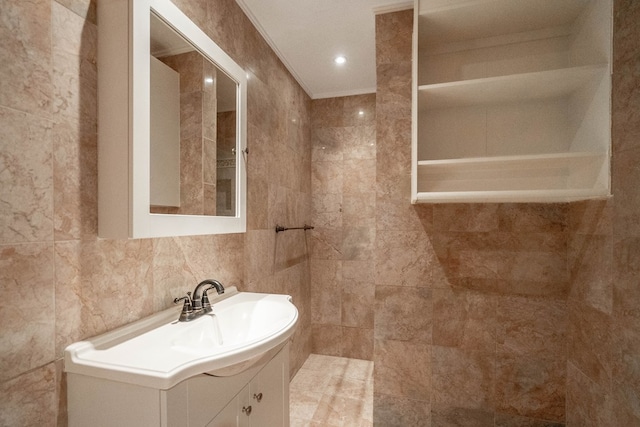 bathroom featuring vanity and tile walls