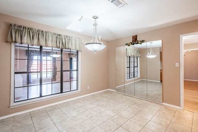 interior space featuring a skylight and light tile patterned floors