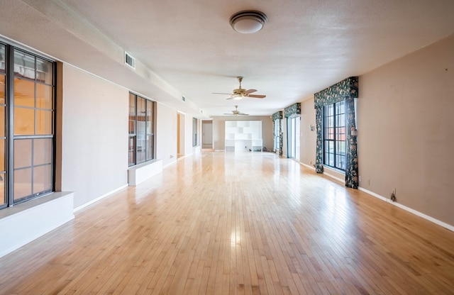 spare room with ceiling fan, light hardwood / wood-style flooring, and a textured ceiling